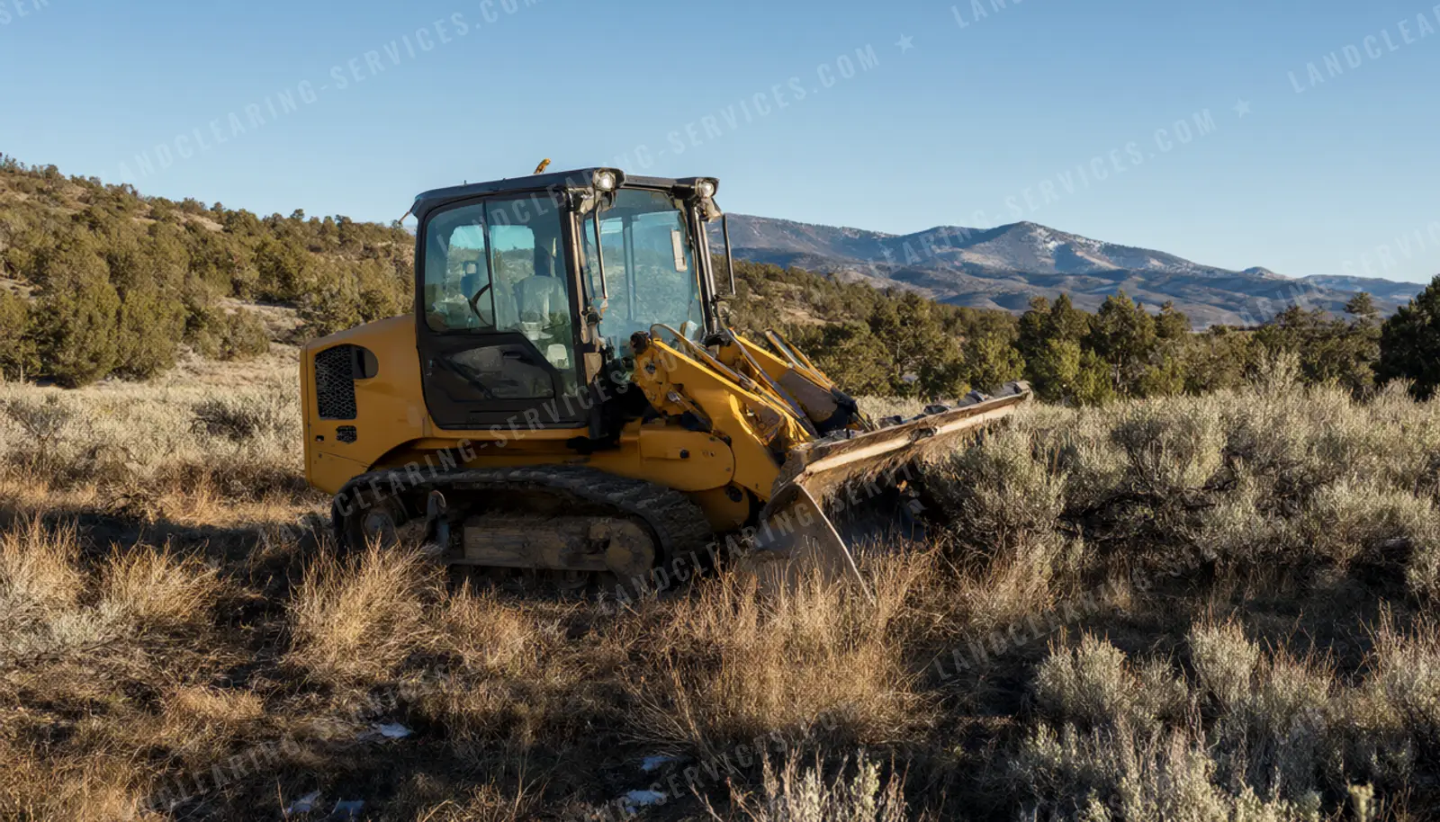 Crawler dozer clearing sagebrush on high country land with mountains behind, land clearing in Utah